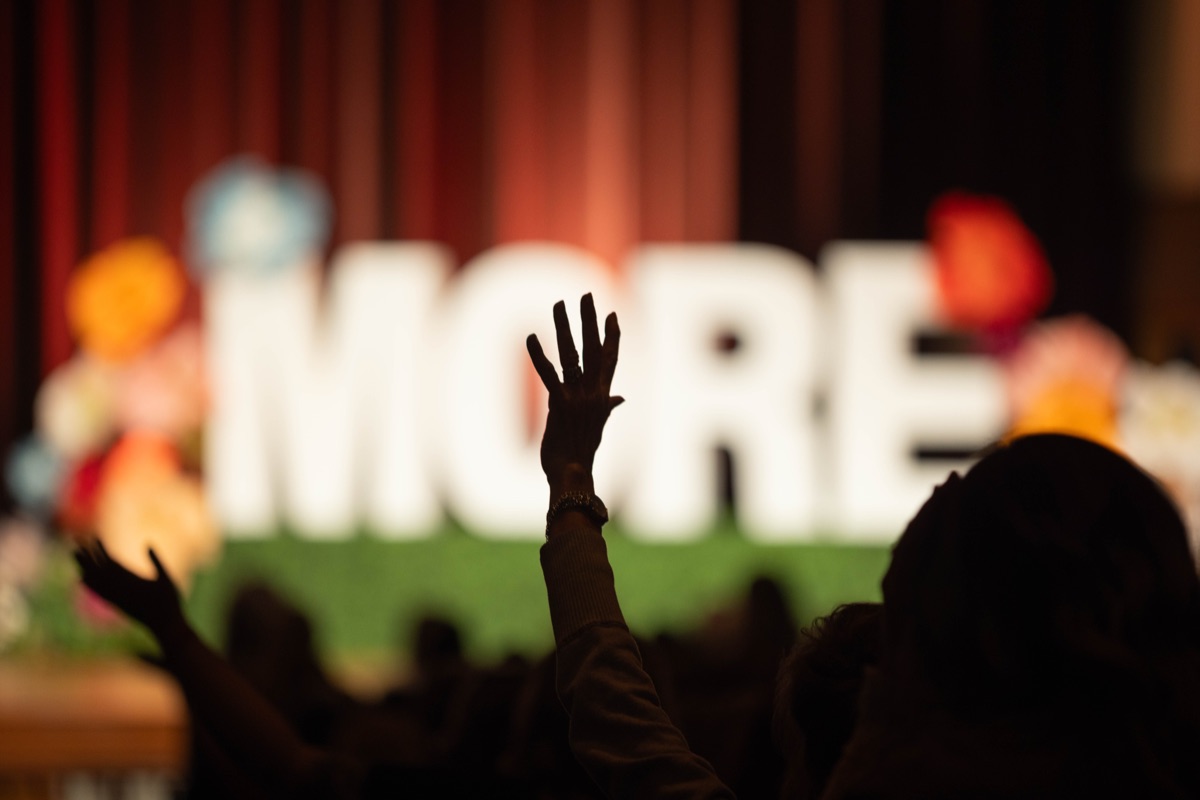 A guest raising her hand during worship